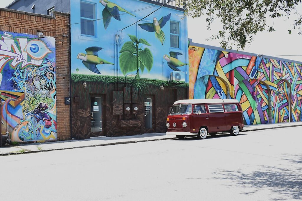 red suv parked beside building during daytime