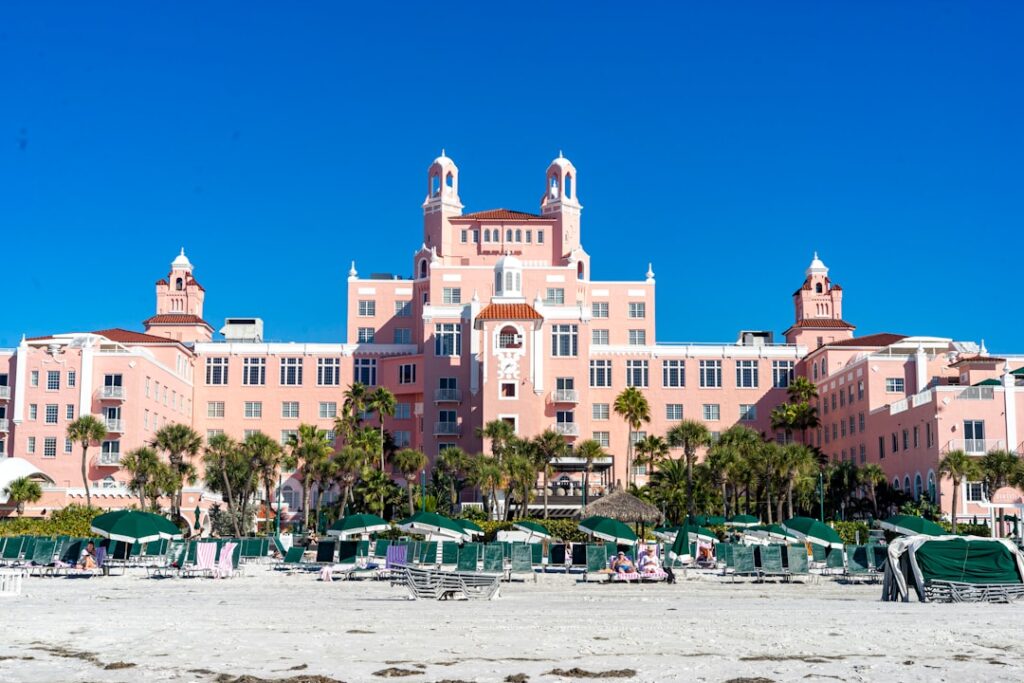 a large pink building sitting on top of a sandy beach