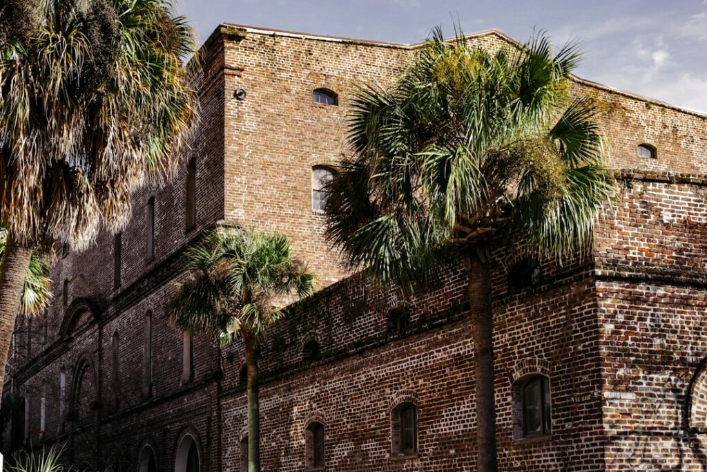 a brick building with palm trees in front of it